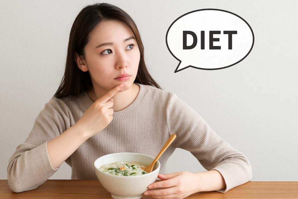 雑炊を前にしてダイエットについて考える女性の写真